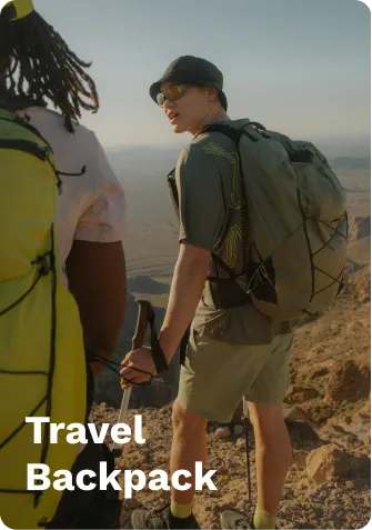 Green travel backpack worn by a man in a green shirt and shorts, hiking on a rocky trail with trekking poles