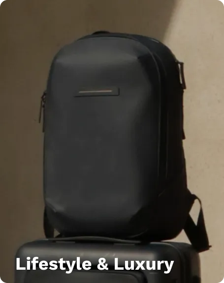 Black lifestyle and luxury backpack with sleek design and zippered compartments, placed on a black suitcase against a beige background.