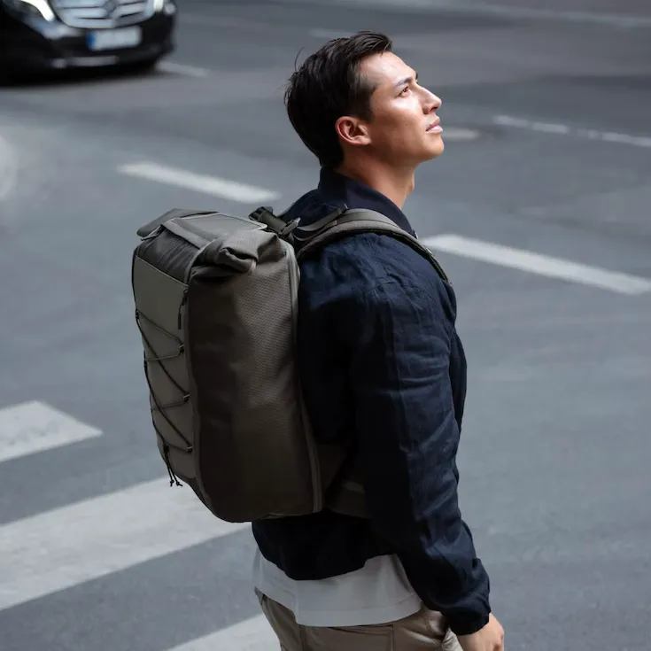 a man carry army green backpack in the street